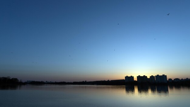 Zonsondergang over meer in Minsk, het district Chizhovka. Wit-Rusland