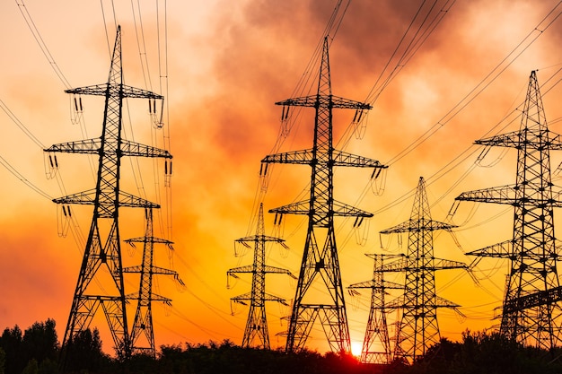 Zonsondergang silhouet hoogspanning elektrische torens Transmissielijnen op de achtergrond van industriële elektriciteitstorens