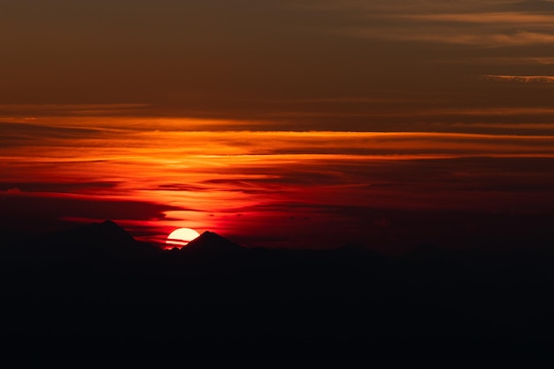 Zonsondergang tussen de bergtoppen op de Alpen