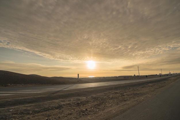 Zonsondergang van een weg die verdwijnt aan de horizon.