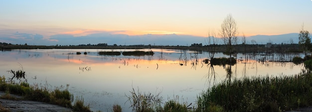 Zonsondergang zomer meer landschap met zon reflectie op het wateroppervlak (in de buurt van Shklo nederzetting, Lviv Oblast, Oekraïne). Twee opnamen naaien een panorama met hoge resolutie.