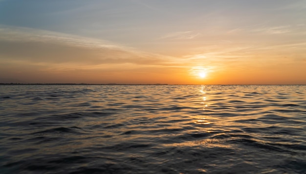 Zonsonderganghemel boven zee in de avond met kleurrijke oranje zonlichtwolk