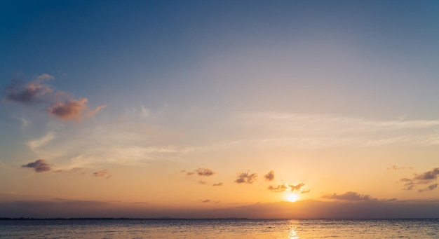 Zonsonderganghemel boven zee in de avond met oranje zonlicht