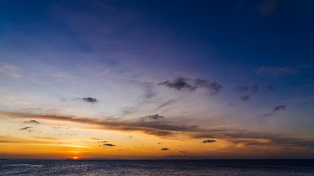 Zonsonderganghemel boven zee in de avond op schemering met oranje zonlicht