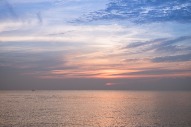 Zonsonderganghemel met schemering op de strandachtergrond.