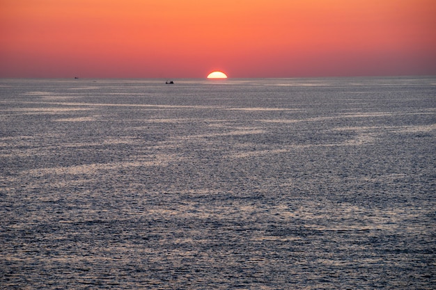 Zonsondergangmening van Promthep-kaap, Phuket-Eiland, Zuid-Thailand, met mooie orang hemel en kleine vissersboot en jacht.