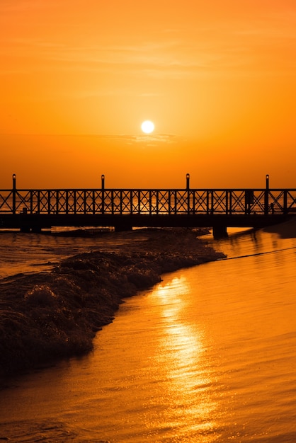 Foto zonsopgang boven de zee. pier op de voorgrond. panorama