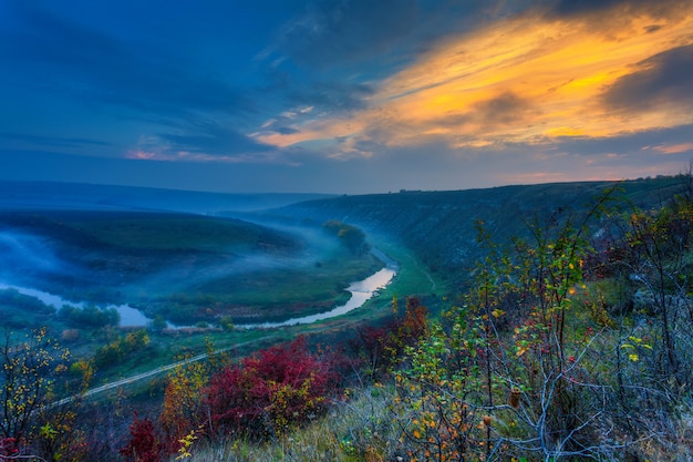 Zonsopgang boven een mistige kleine rivier