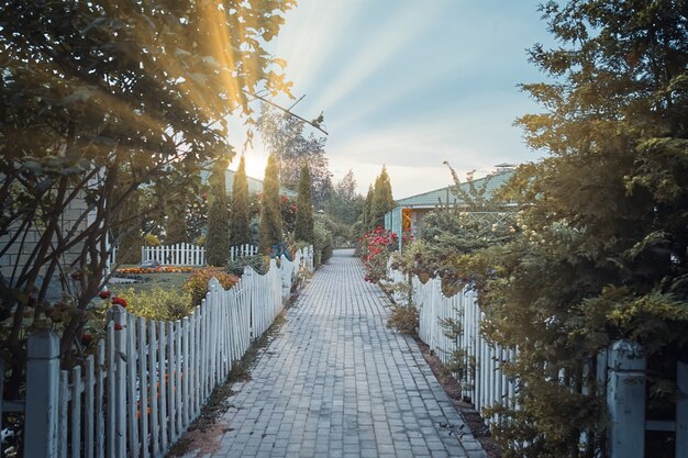 Zonsopgang in kleine dorpsstoep tussen huisjes en tuinen kleine hekken rond weg mooi huis...