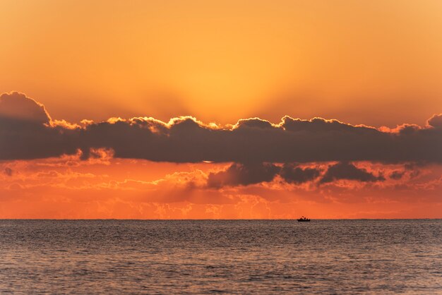 Zonsopgang, zonsondergang aan de zeehorizon en oranje wolken