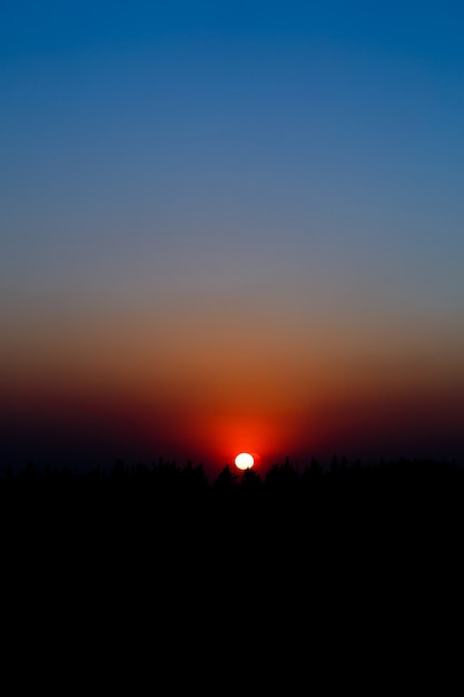 Zonsopgang/zonsondergang met gloeiende kleurrijke luchten. Verbazingwekkend natuurlijk zonlicht, dat de aarde verlicht. Magische kleuren die vanaf de horizon stralen en stralen. Dag eindigt ergens en begint ergens anders