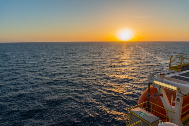 Zonsopgangmening van zeeboringsinstallatie met donkerblauwe zeewater en schemeringhemel.