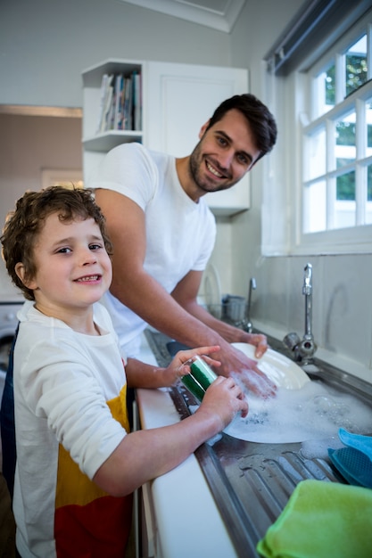 Zoon die vader in waswerktuigen helpt