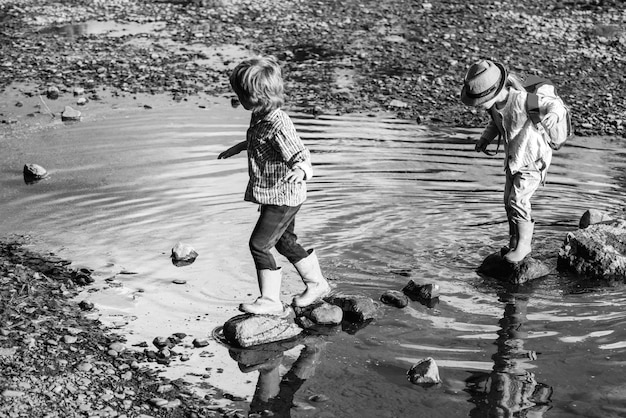 Zoon en dochter spelen in de rivier kinderen spelen op bergbeek kinderen genieten van een heerlijk bedrag