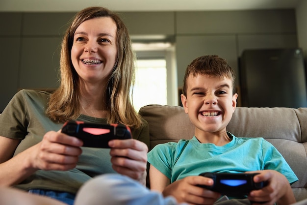 Zoon en moeder spelen thuis een videogame. Familie tijd samen doorbrengen