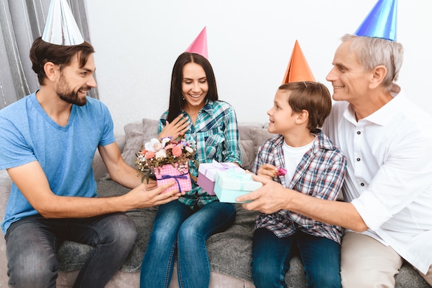 Zoon en schoonvader feliciteren moeder met de verjaardag.