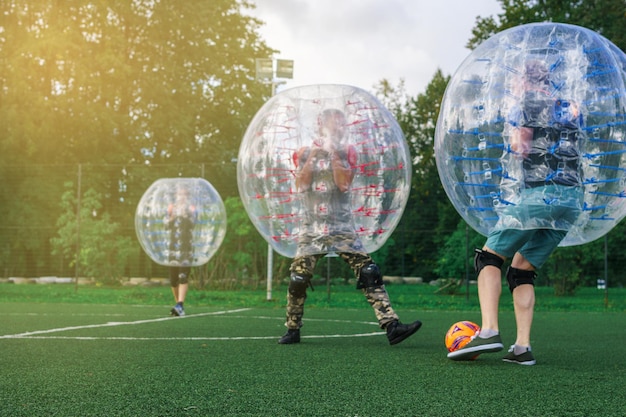 Photo zorb football players mens are playing in bumper boll outdoors