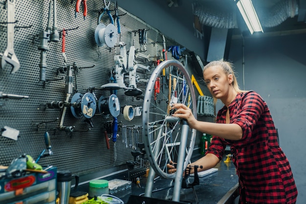 Zorg voor je wielen. Vrouwenwerktuigkundige die in de garage werken