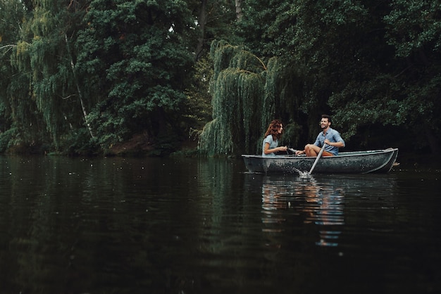 Zorgeloos dagje samen. Mooie jonge paar glimlachen terwijl u geniet van een romantische date op het meer