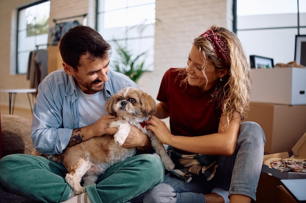 Zorgeloos echtpaar met hun hond genieten in hun nieuwe huis