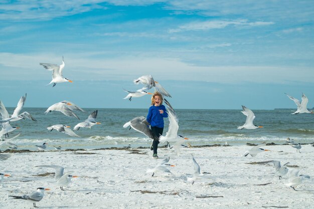 Zorgeloos kind kleine jongen die plezier heeft op het strand van Miami gelukkig schattig kind dat in de buurt van de oceaan jaagt