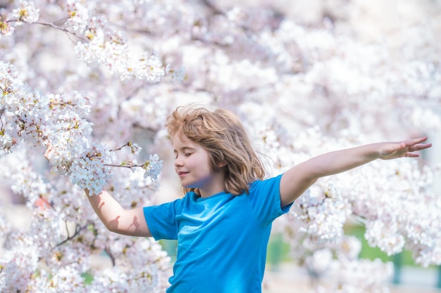 Zorgeloos kind met opgeheven handen mediteert zich rustig voelen bij kersenboom kind ontspannen op de lente natuur