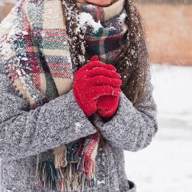 Zorgeloos meisje, lachend op een winterse dag. Buitenfoto van jonge Europese vrouw die op een sneeuwochtend dichtbij het huis bedriegt.