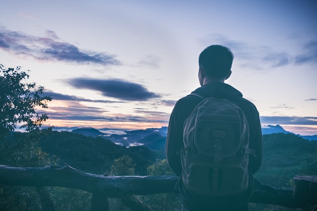 Zorgeloze gelukkige mens die van aard bovenop bergklip genieten met zonsopgang. Vrijheid concept