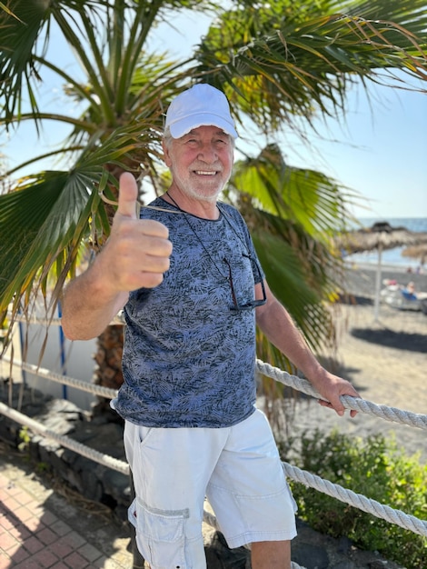 Zorgeloze oudere man op zeevakantie die geniet van een zonnige dag en een gelukkige pensioenleven.