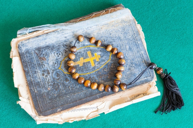 Foto zorgparels op oud psalmboek op groene tafel