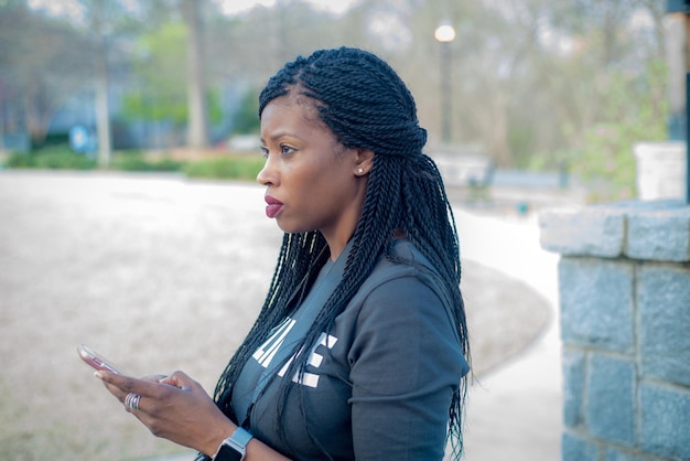 Zorgvuldige vrouw met mobiele telefoon in de stad