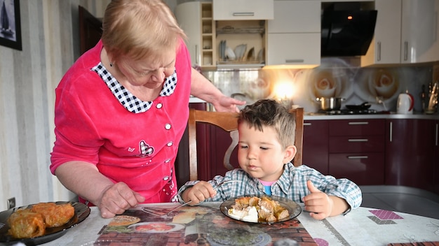 Zorgzame grootmoeder met haar kleinzoon eten.