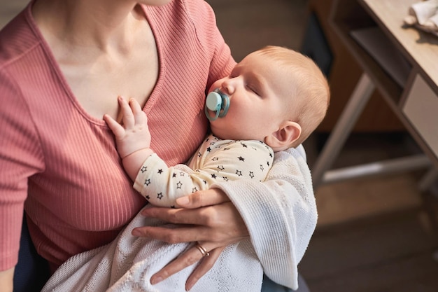 Foto zorgzame moeder die een slaperige baby vasthoudt