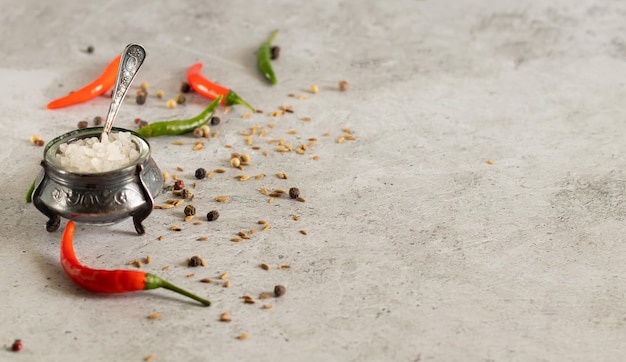 Foto zout paprika peperkorrels komijn op lichte betonnen ondergrond met kopieerruimte