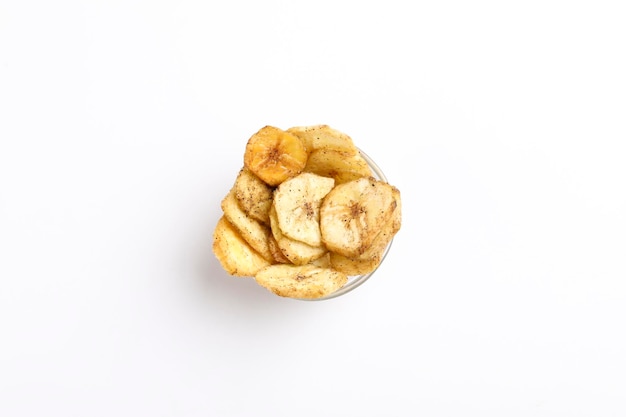 Zoute bananenchips in kom op witte achtergrond