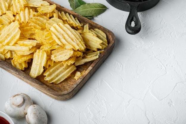 Zoute chips snack set, met dompelen sauzen tomaat dip zure room, op witte stenen ondergrond