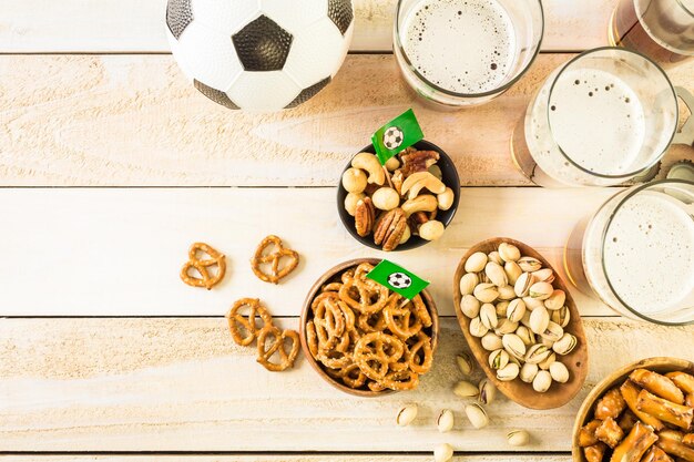 Zoute snacks en bier op tafel voor een voetbalfeest.