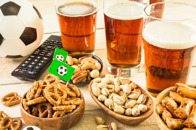 Zoute snacks en bier op tafel voor een voetbalfeest.