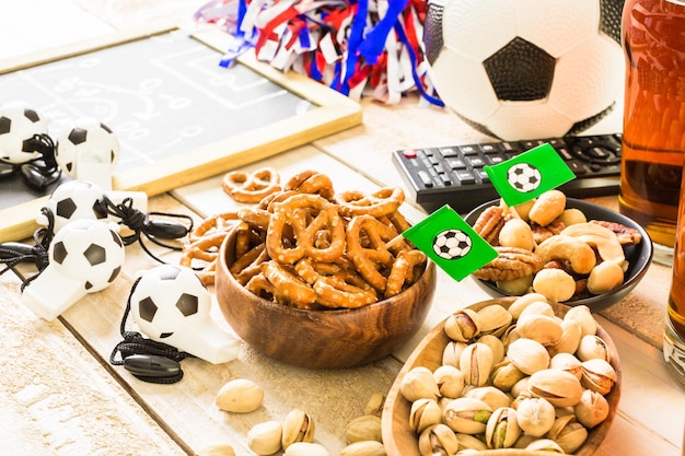 Zoute snacks en bier op tafel voor een voetbalfeest.