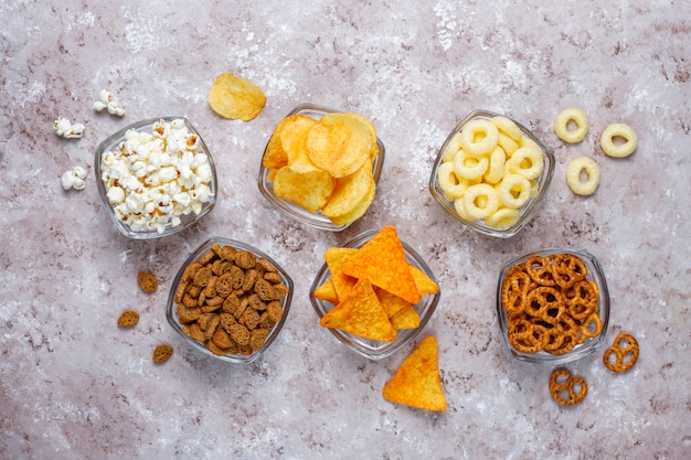 Zoute snacks. Pretzels, chips, crackers, popcorn in kommen. Ongezonde producten. voedsel slecht voor figuur, huid, hart en tanden. Assortiment van snelle koolhydraten