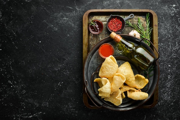 Zoute snacks voor bier Bovenaanzicht Op een zwarte achtergrond