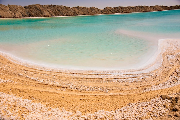 Zoutmeer met turkoois water en wit zout aan de kust bij de Siwa-oase, Egypte