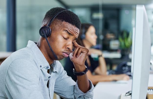 Zoveel te doen vandaag Shot van een jonge callcentermedewerker die er moe uitziet in een kantoor