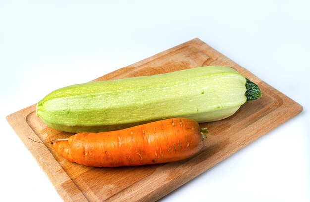 Zucchini and carrots on a wooden board new harvest copy space