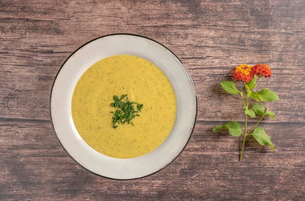 Zucchini cream in an old porcelain plate on a rustic table