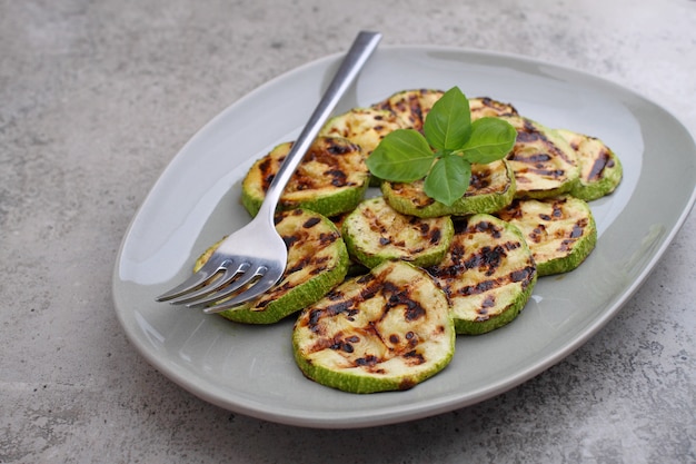 Photo zucchini cut into slices and grilled fried. decorated with a basil.