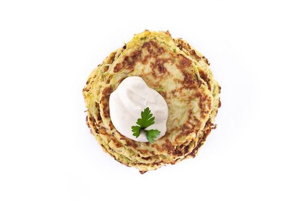 Zucchini fritters with yogurt sauce isolated on white background Vegetable pancakes