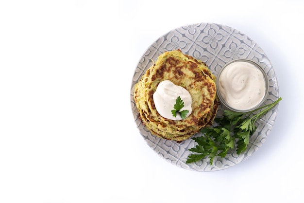 Zucchini fritters with yogurt sauce isolated on white background