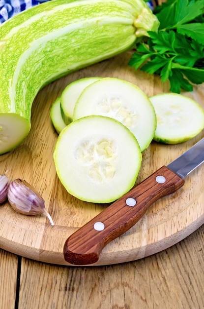 Zucchini green with knife on board