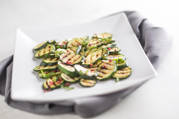 Zucchini. Grilled zucchini with red spice on white plate.